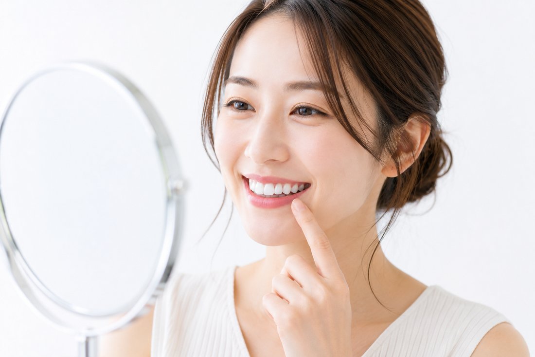 鏡で白い歯を確認する女性